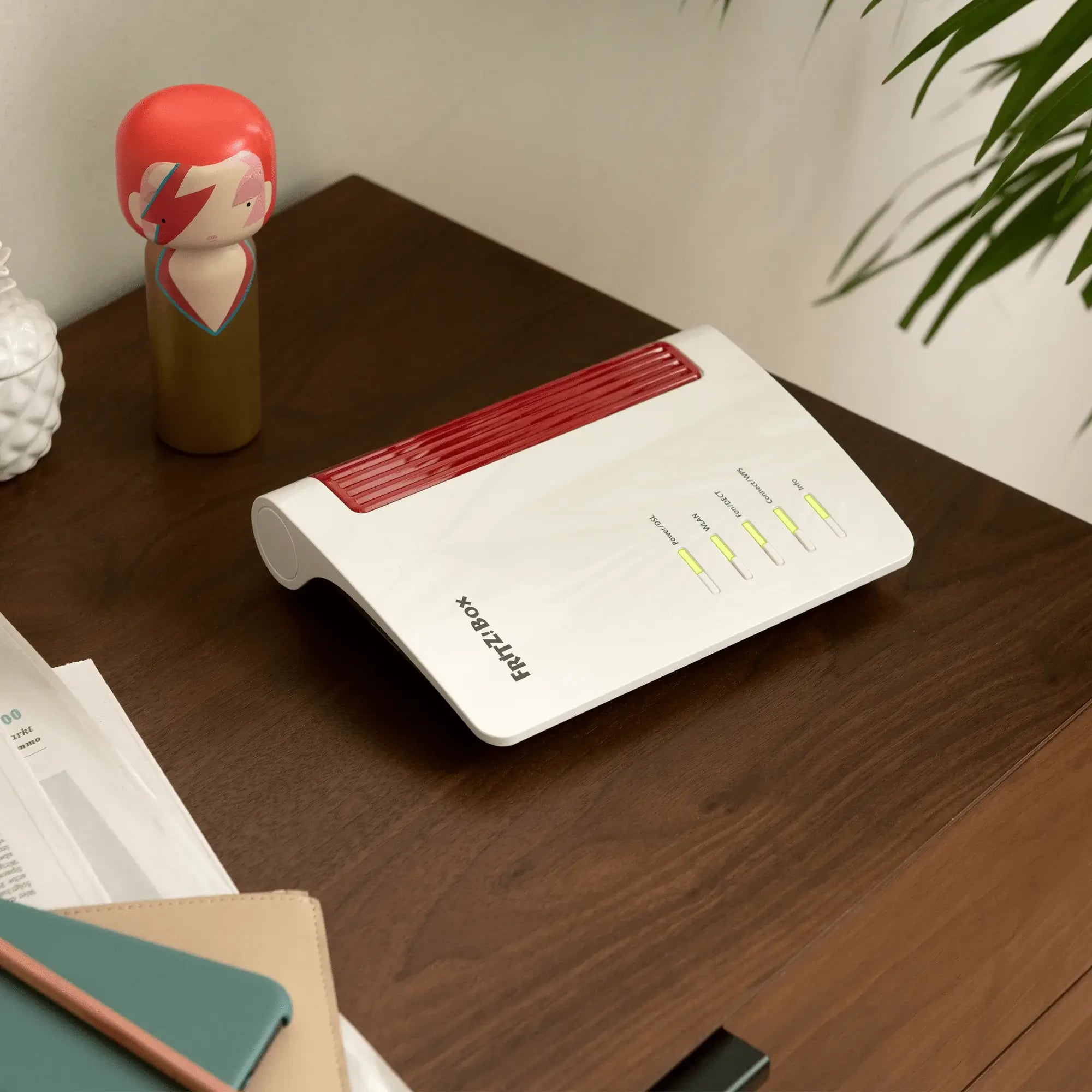 FRITZ!Box 7510 Router auf einem Holztisch mit einer dekorativen Figur, ideal für Wi-Fi 6 Heimnetz.